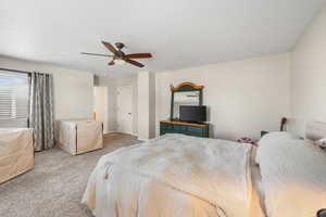 Bedroom featuring baseboards, light carpet, and ceiling fan