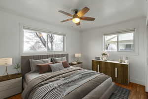 Bedroom featuring dark wood-style floors, ceiling fan, ornamental molding, and baseboards