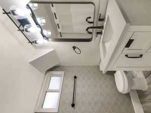 Full bath with wood finished floors, vanity, toilet, and baseboards