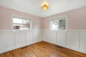 Spare room with visible vents, a wealth of natural light, and wainscoting