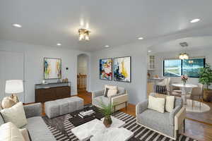 Living area featuring recessed lighting, arched walkways, wood finished floors, and ornamental molding