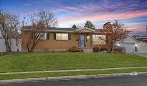 Ranch-style house featuring an attached garage, a chimney, fence, and a front yard