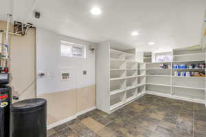 Laundry area with stone finish flooring, washer hookup, a textured ceiling, and recessed lighting