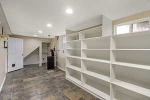 Below grade area featuring recessed lighting, stone finish flooring, and baseboards