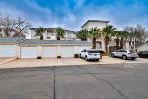 Townhome / multi-family property featuring stucco siding, a tile roof, and community garages