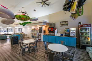 Dining area featuring visible vents, ceiling fan, wood finished floors, and a community bar