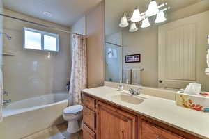 Full bath featuring vanity, toilet, and shower / bathtub combination with curtain