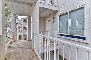 Property entrance featuring a balcony and stucco siding