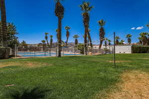 View of yard featuring a tennis court and fence