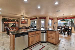 Kitchen with a sink, visible vents, open floor plan, and dishwasher