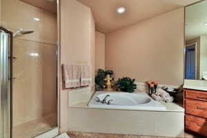 Full bathroom with a stall shower, tile patterned floors, a garden tub, vanity, and recessed lighting