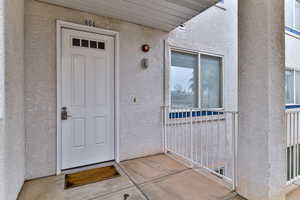 Entrance to property with stucco siding
