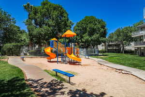 Community play area with a lawn and fence