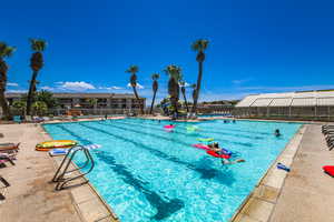 Community pool with a patio and fence