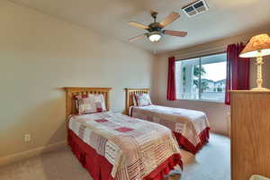Carpeted bedroom featuring baseboards, visible vents, ceiling fan, and a textured ceiling