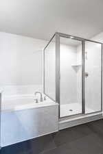 Bathroom featuring a textured ceiling, a stall shower, tile patterned flooring, and a garden tub