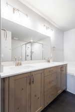 Full bath with double vanity, a sink, and tile patterned floors