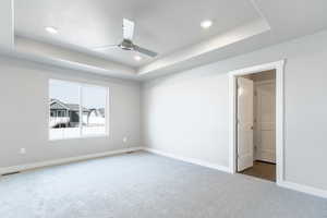 Unfurnished bedroom featuring baseboards, visible vents, a raised ceiling, carpet floors, and recessed lighting