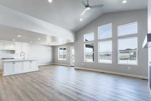 Unfurnished living room featuring baseboards, recessed lighting, a ceiling fan, and light wood-style floors