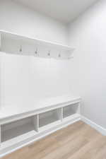 Mudroom featuring light wood-style floors and baseboards