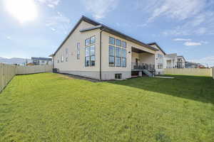 Back of property featuring a fenced backyard, a lawn, and cooling unit