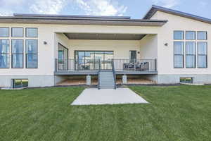 Back of house featuring a yard and stucco siding