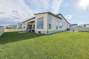 Rear view of house featuring stucco siding, a fenced backyard, a patio area, and a yard