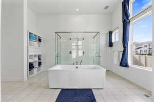 Bathroom with a freestanding tub, visible vents, a shower stall, and tile patterned floors