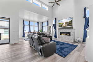 Living room with a healthy amount of sunlight, a towering ceiling, and wood finished floors