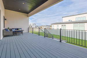 Deck with a residential view, a yard, and fence