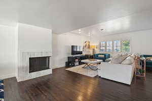 Open living room with plantation shutters, marble surround fireplace and plenty of natural light.