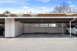 View of covered extra wide double carport with locked door leading into private patio.