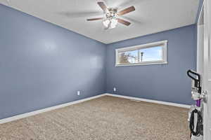 Spare room with carpet floors, a textured ceiling, and baseboards