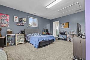 Bedroom featuring attic access, visible vents, and carpet flooring