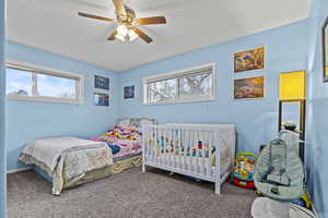 Carpeted bedroom with ceiling fan