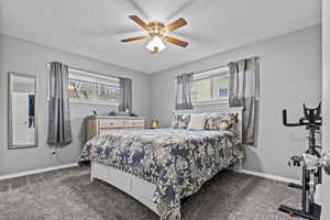 Bedroom featuring a textured ceiling, carpet floors, a ceiling fan, and baseboards