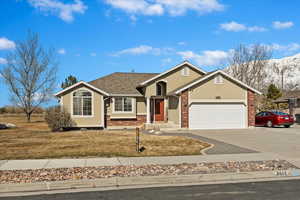 Single story home featuring brick siding, concrete driveway, roof with shingles, an attached garage, and stucco siding