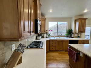 Kitchen featuring brown cabinetry, decorative backsplash, Gas built in range