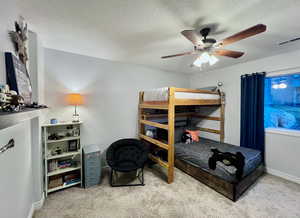 Bedroom 1 featuring baseboards, visible vents, a ceiling fan, a textured ceiling, and carpet flooring