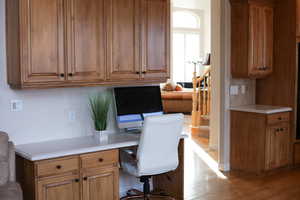 Kitchen office nook featuring light wood-style floors and built in desk