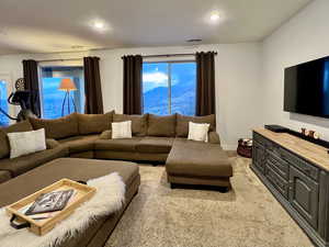 Carpeted living area with baseboards, visible vents, and a textured ceiling