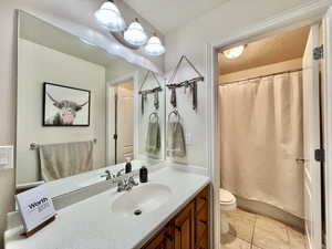 Jack & Jill Full Bathroom with a textured ceiling, vanity, tile patterned flooring, and toilet