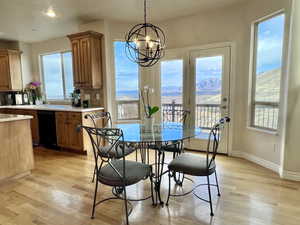 Dining space with light wood-type flooring, a mountain view, Doors lead to deck