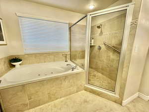 Primary Bathroom featuring a jetted tub, a shower stall, and tile patterned floors