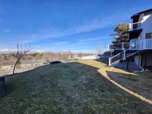 View of yard featuring stairway, a deck, and fence