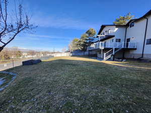 View of yard with stairway, fence, and a wooden deck