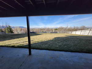 View of yard with a patio area, fence, and a mountain view