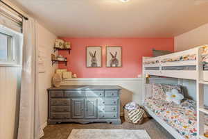 Carpeted bedroom with a wainscoted wall