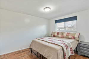 Bedroom featuring wood finished floors and baseboards