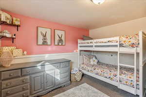 Bedroom with a wainscoted wall and carpet flooring